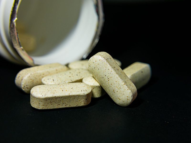Vitamin tablets spilling from a bottle