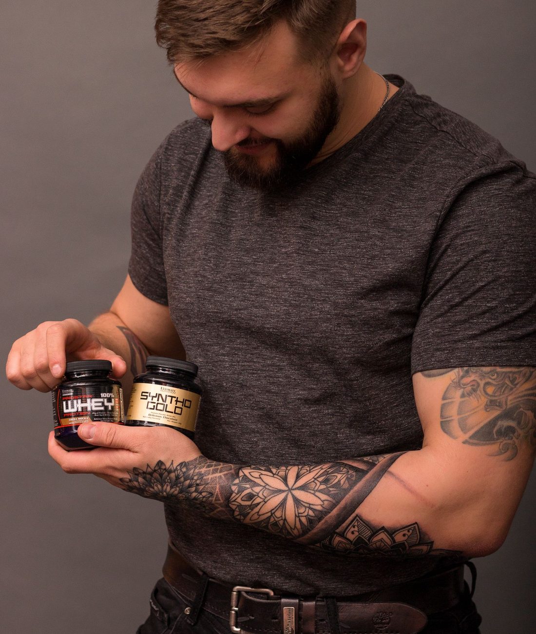 A man comparing two tubs of whey protein